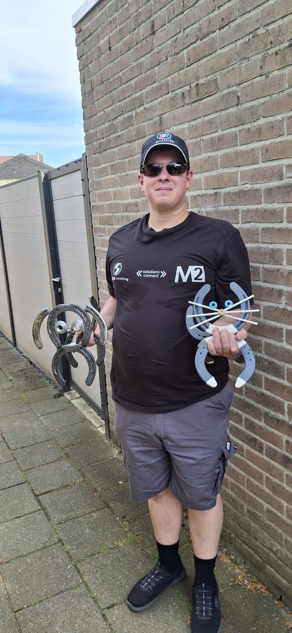 Jeroen met twee handgemaakte hoefijzerkunstwerken